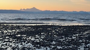 A rocky beach with a mountain range in the background. - 3-bedroom House in Ninilchik by Deep Creek (Ninilchik)