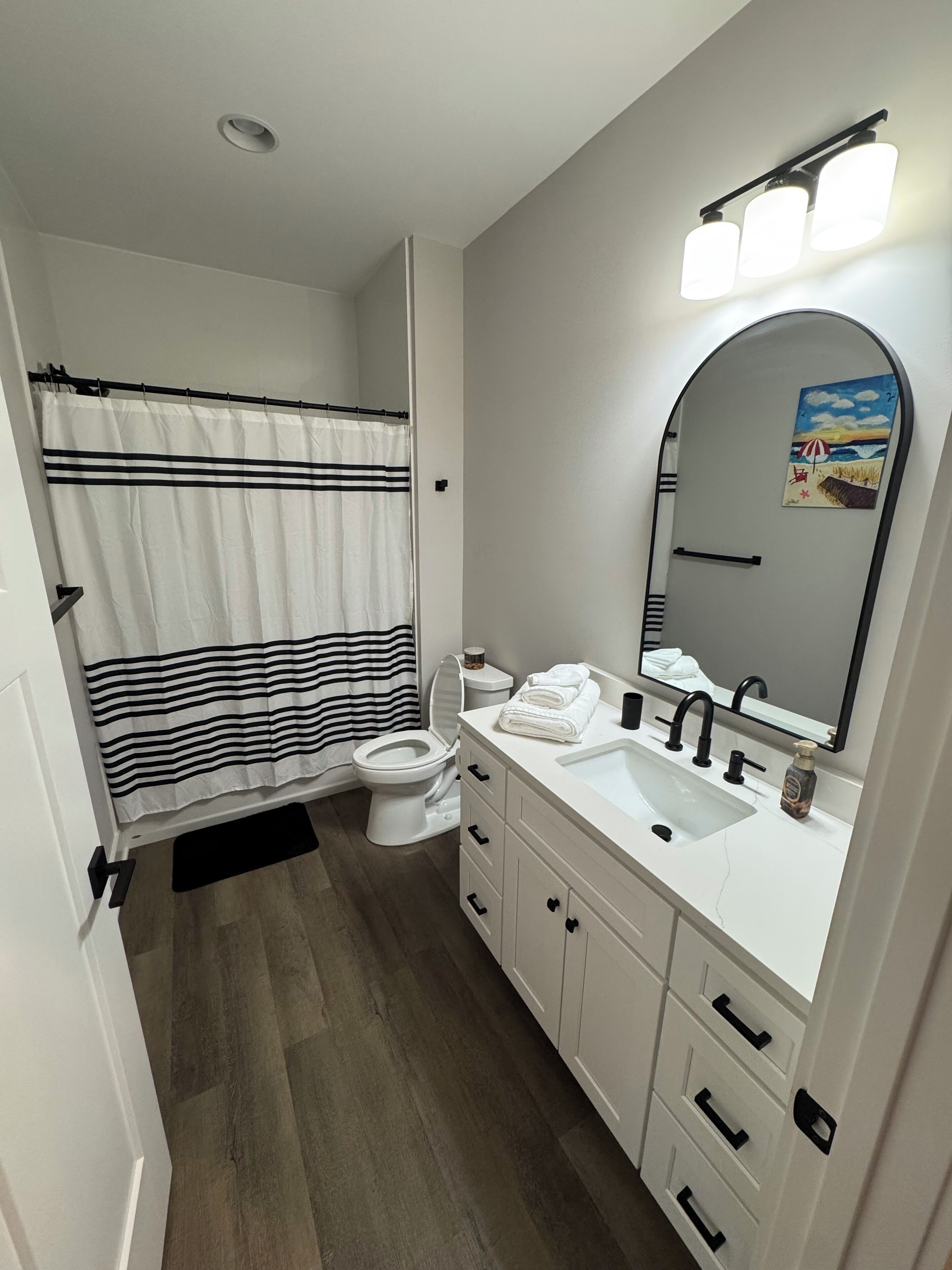 A bathroom with a toilet, sink, and shower curtain.