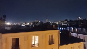 A nighttime cityscape with illuminated buildings and a clear sky.