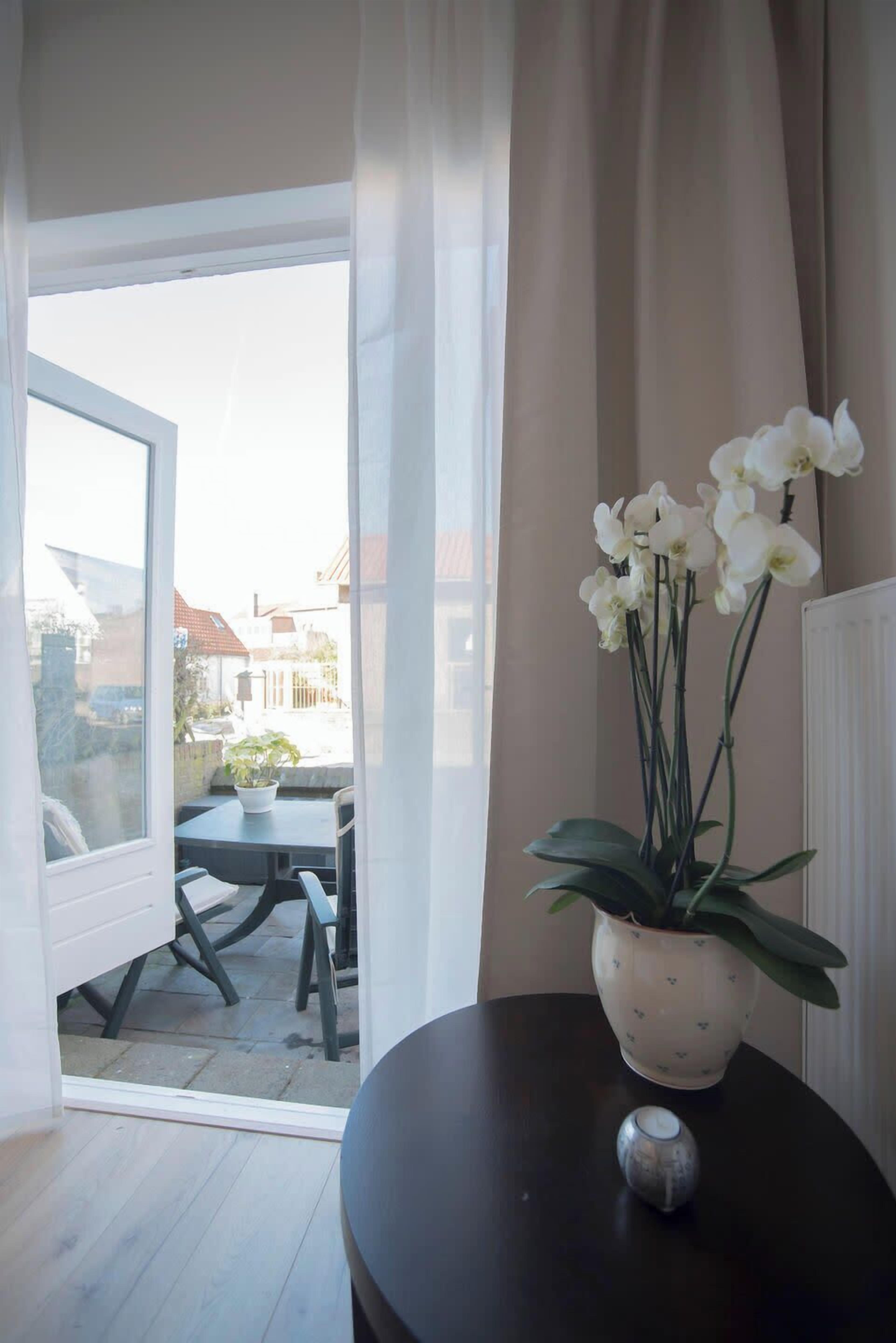 A room with a view through a glass door to an outdoor patio area.