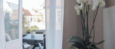 A room with a view through a glass door to an outdoor patio area.