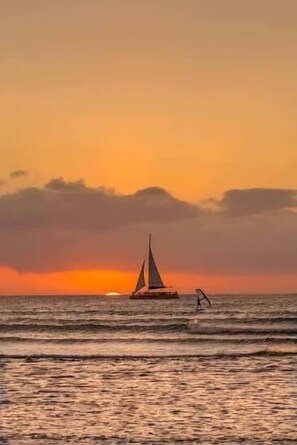 Een zeilboot op rustig water tijdens de zonsondergang.