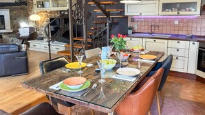 A dining area with a glass-top table set for four, surrounded by leather chairs. A staircase with wrought iron railings is visible in the background. - 3 bedroom gorgeous home in Krasica (Krasica)
