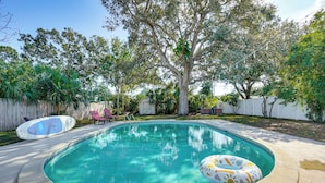 A backyard with a swimming pool, surrounded by trees and a wooden fence. - Convenient Oasis in St Pete, 4 Mi to Pier & Dtwn! (St. Petersburg)