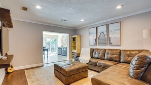A spacious living room with a leather sofa, ottoman, and a large rug. - Convenient Oasis in St Pete, 4 Mi to Pier & Dtwn! (St. Petersburg)