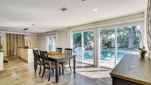 A spacious kitchen with a dining area, large windows, and a view of a swimming pool. - Convenient Oasis in St Pete, 4 Mi to Pier & Dtwn! (St. Petersburg)