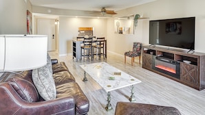A living room with a fireplace, a television, and a dining area with chairs and a table.
