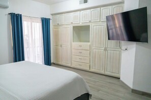 A bedroom with a bed, a wardrobe, and a TV. - Casa Cielo Azul (Puerto Peñasco)