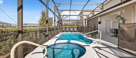 Une piscine extérieure couverte, dotée d’une structure en forme de pergola, entourée d’une clôture et offrant une vue sur des immeubles résidentiels.