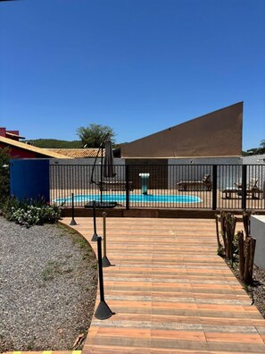 حمّام سباحة خارجي، مظلات على حمّام السباحة، مقاعد للتشمس