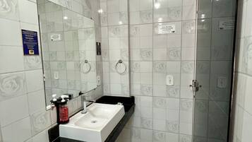 Chuveiro, toalhas de banho, sabonete, papel higiênico