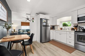 A modern kitchen with white cabinets, a stainless steel refrigerator, and a built-in oven. - Charlotte Chalet | Private Yard & Play Set (Sarasota)