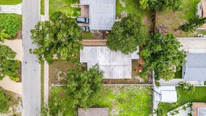 Vue aérienne d’un quartier résidentiel avec plusieurs maisons, une piscine et une route.