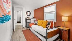 Une chambre à coucher de taille réduite, comprenant un lit, une table de chevet et une fenêtre.