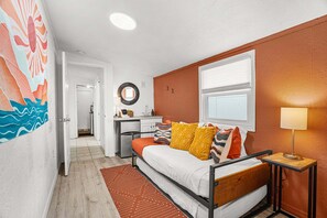 Ein kleines Schlafzimmer mit Bett, Nachttisch und Fenster.