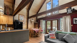 Ein gemütliches Blockhaus-Interieur mit Essbereich, Küche und einer Couch mit Blick.
