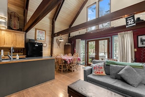 Ein gemütliches Blockhaus-Interieur mit Essbereich, Küche und einer Couch mit Blick.