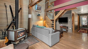 Ein gemütliches Wohnzimmer mit Kamin, einer Couch und einem Fernseher.