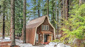 Eine kleine Holzhütte mit geneigtem Dach und einer Veranda.