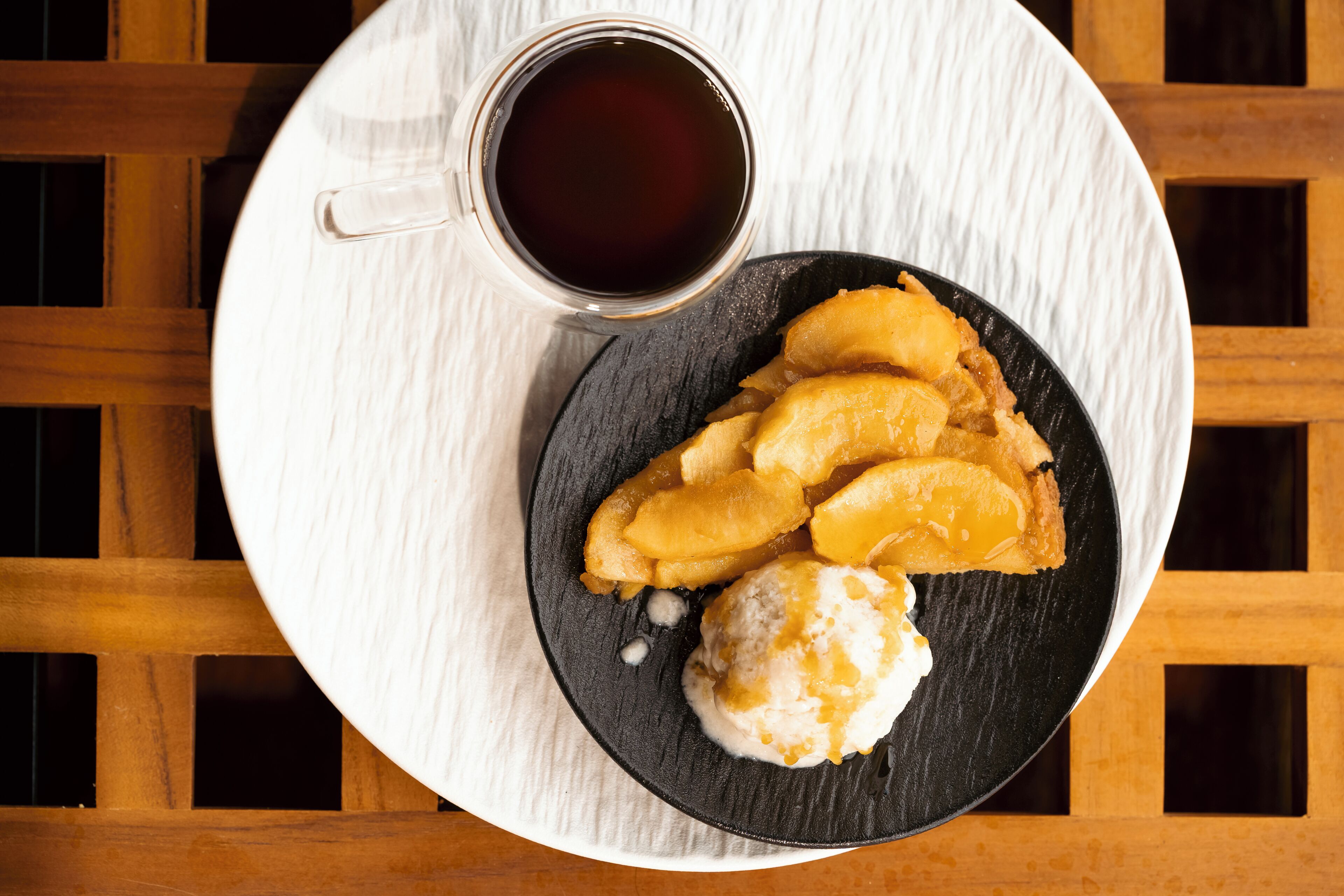 Un plato de comida con una taza de líquido oscuro a su lado.