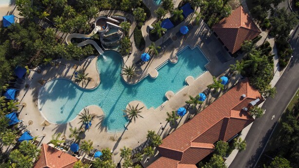 An aerial view of a resort with multiple swimming pools, palm trees, and beach areas. - The villa where dreams come true! (Davenport)
