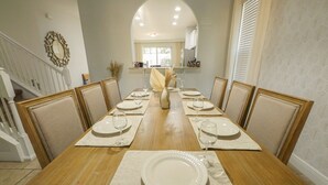A dining room with a wooden table set for six with white plates and glasses. - The villa where dreams come true! (Davenport)