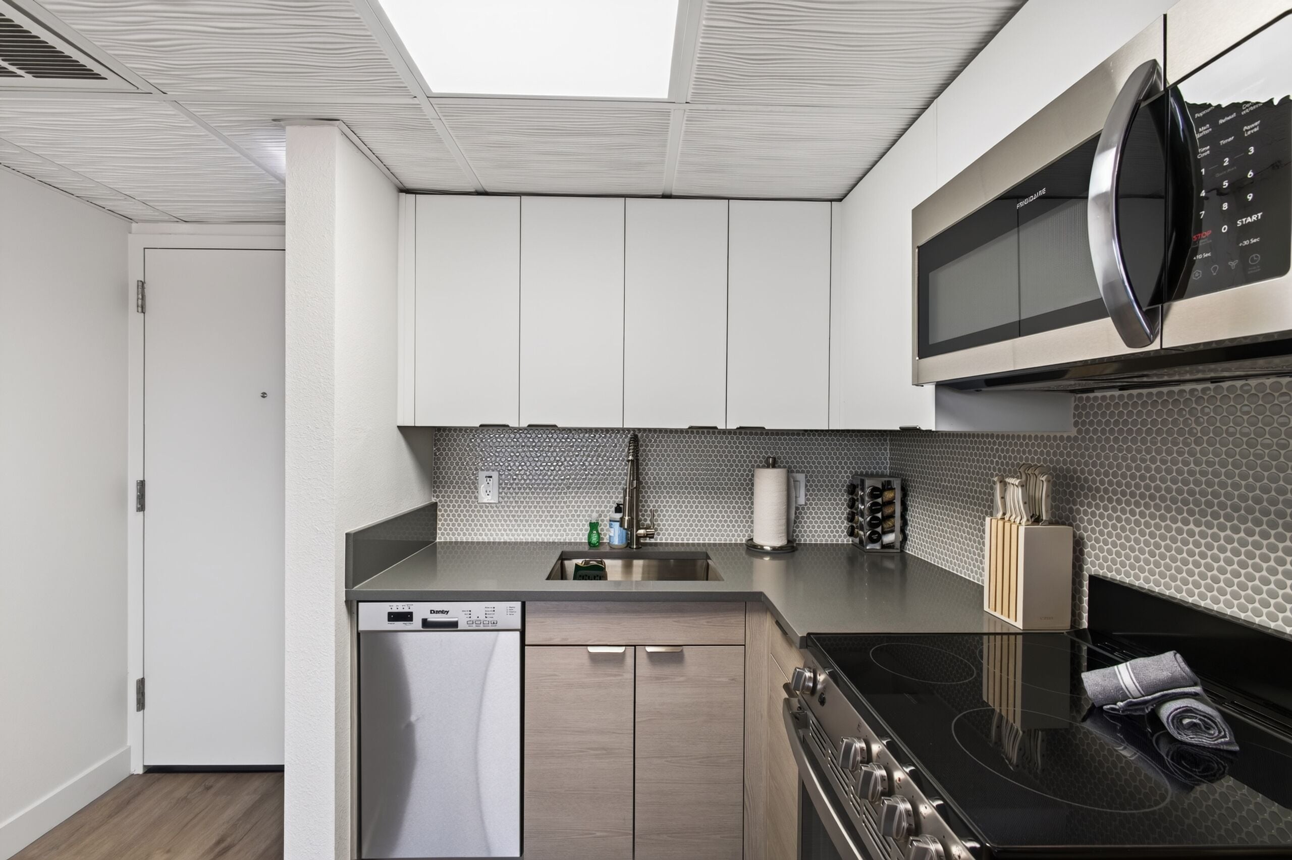 A modern kitchen with a dishwasher, stove, and microwave.