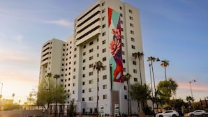 Un hotel de varios pisos con un gran mural vertical en una de sus fachadas.