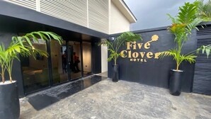 Eksteriørbillede af Five Clover Hotel med en moderne facade, stor glasindgang og plantekasser.