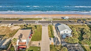 Eine Küstenstraße mit Blick auf den Strand, Häusern und einem klaren Himmel.