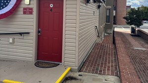 A building with a red door, a sign reading "The Paul Revere Suite," and a yellow tactile paving at the entrance. - Charming & luxurious 1-bedroom condo, Kitchen, Washer, dryer, parking, King Bed. (Hagerstown)