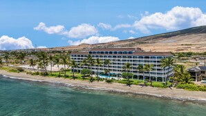 Un hôtel situé en bord de mer, doté de nombreux balcons, d’une piscine et offrant une vue sur l’océan et la plage.