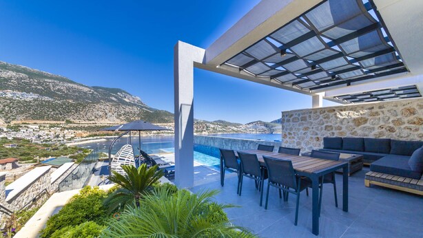 An outdoor patio with a pool, seating area, and a view of the coastline. - Discover your Kalkan escape – private pool and sea views (Kalkan Centre)