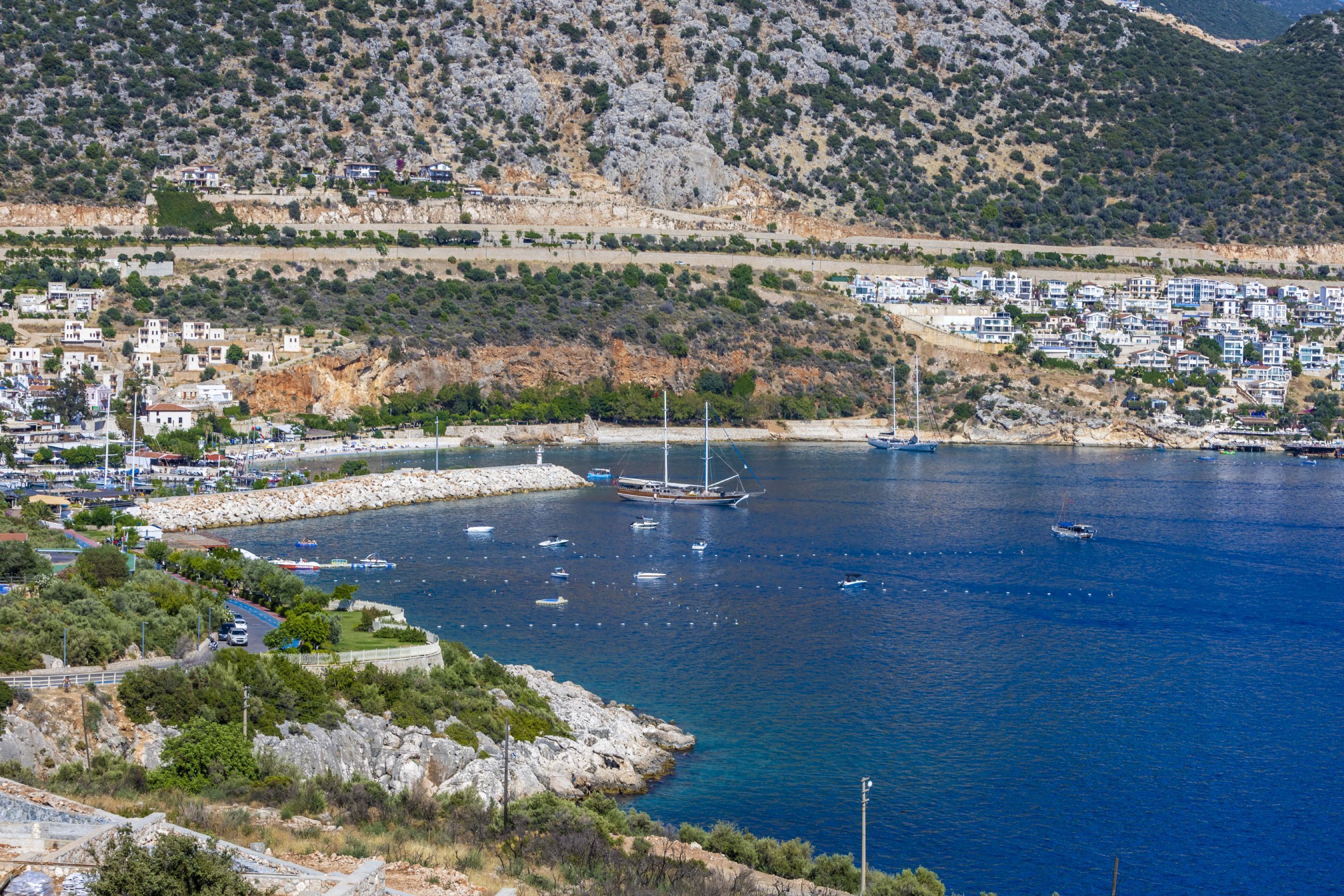 A coastal town with a marina, boats, and buildings along the shore.