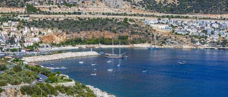 A coastal town with a marina, boats, and buildings along the shore.