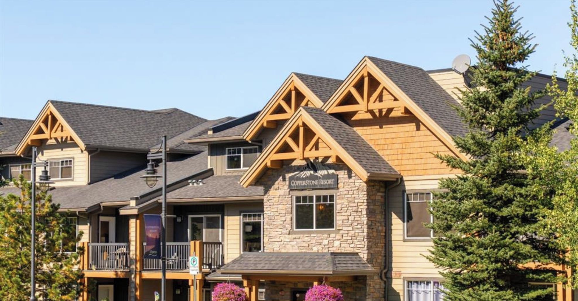 A resort building with a stone facade, multiple balconies, and a sign reading "Welcome to 5106 Copperstone Resort".