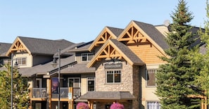 Un bâtiment d’hôtel de luxe avec une façade en pierre, de nombreux balcons et une enseigne indiquant : « Bienvenue au 5106 Copperstone Resort ».
