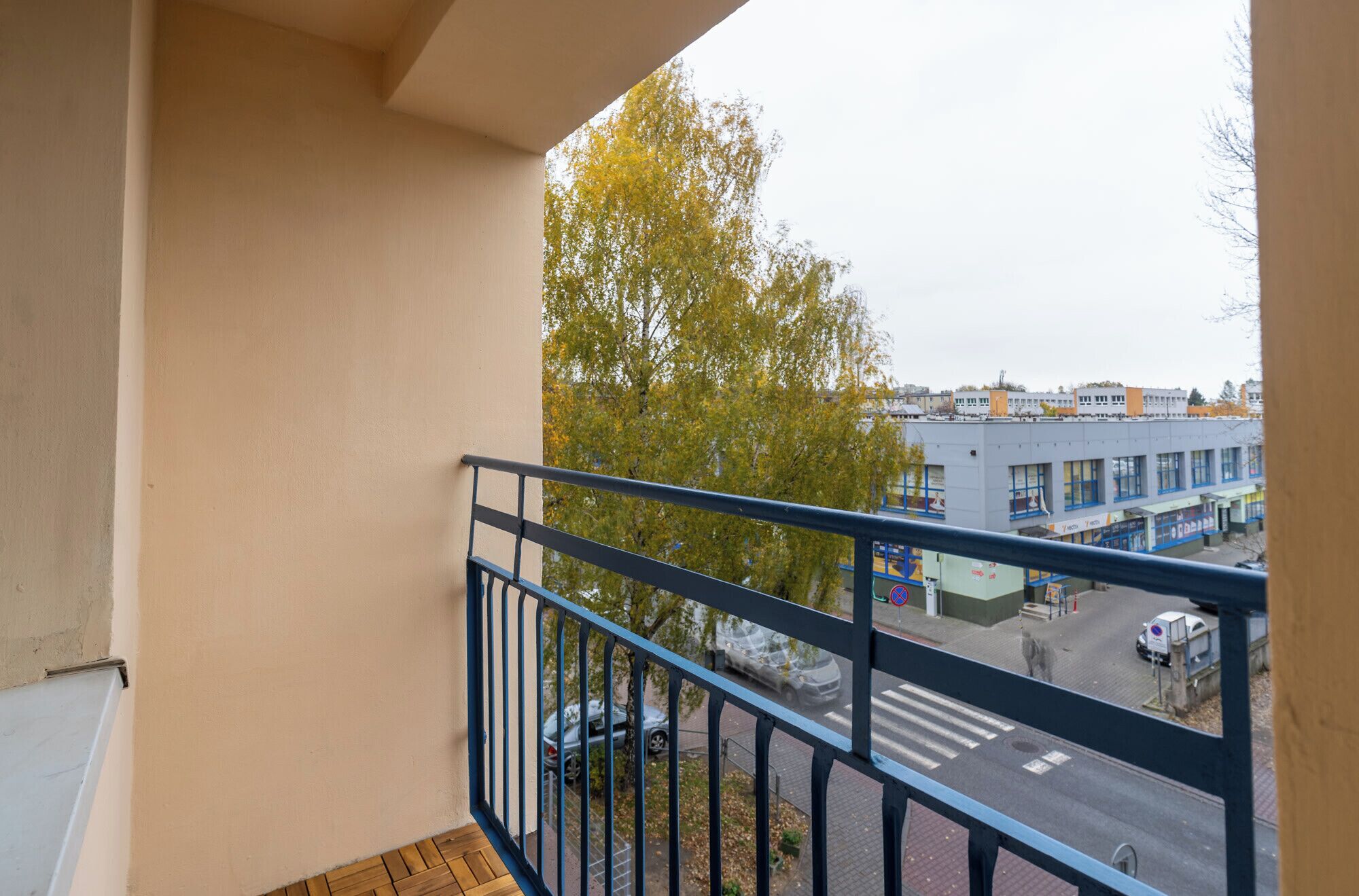 En balkon med udsigt over en gade og bygninger.