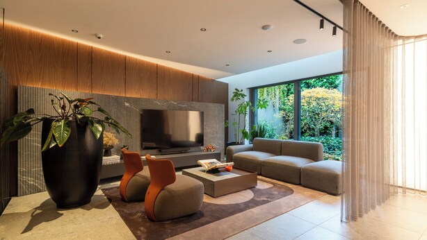 A modern living room with a large flat-screen TV, comfortable seating, and a view of greenery outside. - Spodek Modern Apartment (Katowice)