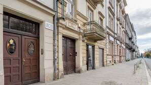 A row of traditional European buildings with large wooden doors and balconies. - Kraków Grzegórzki Deluxe Studio (Kraków)