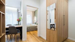 Une chambre à coucher moderne avec une armoire en bois, une table de chevet et un lit.