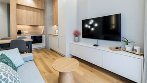 Un salon moderne doté d’un téléviseur à écran plat, de meubles en bois, d’un coin repas et d’un espace salon confortable.