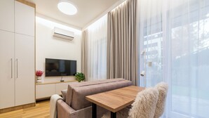 Ein modernes Wohnzimmer mit einer Couch, einem Holztisch und einem Fernseher.