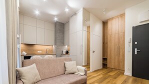 Ein modernes Wohnzimmer mit einer Couch, Holzboden und Einbauschränken.