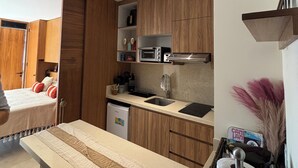 Uma cozinha compacta com armários de madeira, micro-ondas embutido e uma pia pequena.