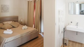 Een hotelkamer met een bed, een badkamer met een wastafel en spiegel, en een douchegordijn.
