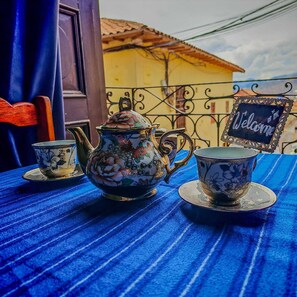 A table set with a teapot, a cup, and saucer, and a 'Welcome' sign on a balcony. - Alojamiento en Casona Colonial Céntrica (Cusco)