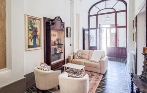 A living room with a sofa, armchairs, a coffee table, a bookshelf, and a large window. - Amazing apartment in Pisa with WiFi (Pisa)