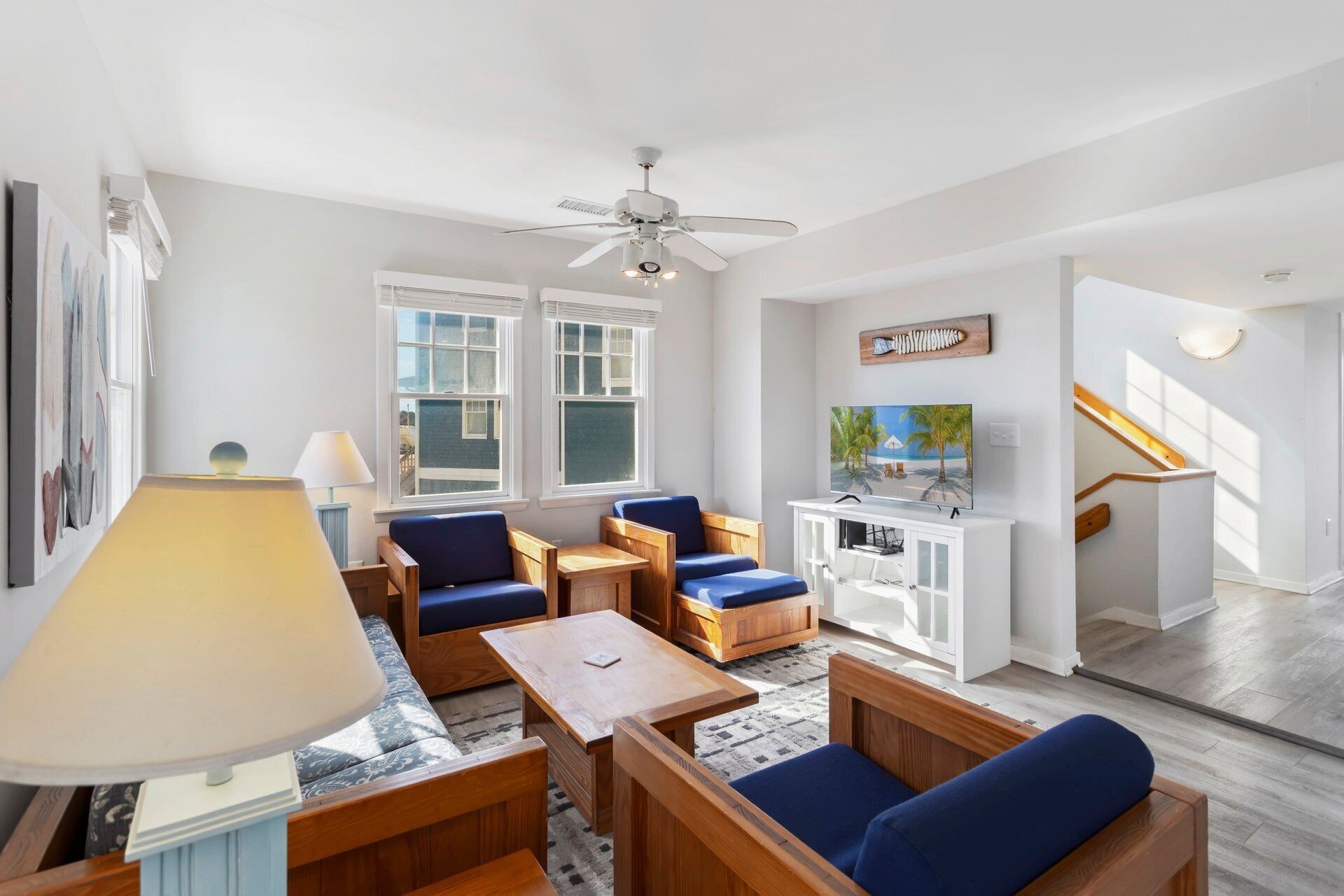 Cozy seating, bright coastal décor, and a TV make the living area perfect for relaxing evenings or family movie nights.
