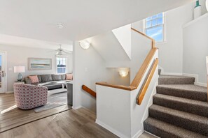 A staircase with wooden handrails and carpeted steps leading to an upper floor.